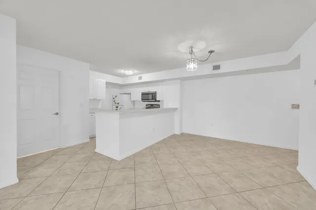 a view of a kitchen with a sink and a chandelier fan