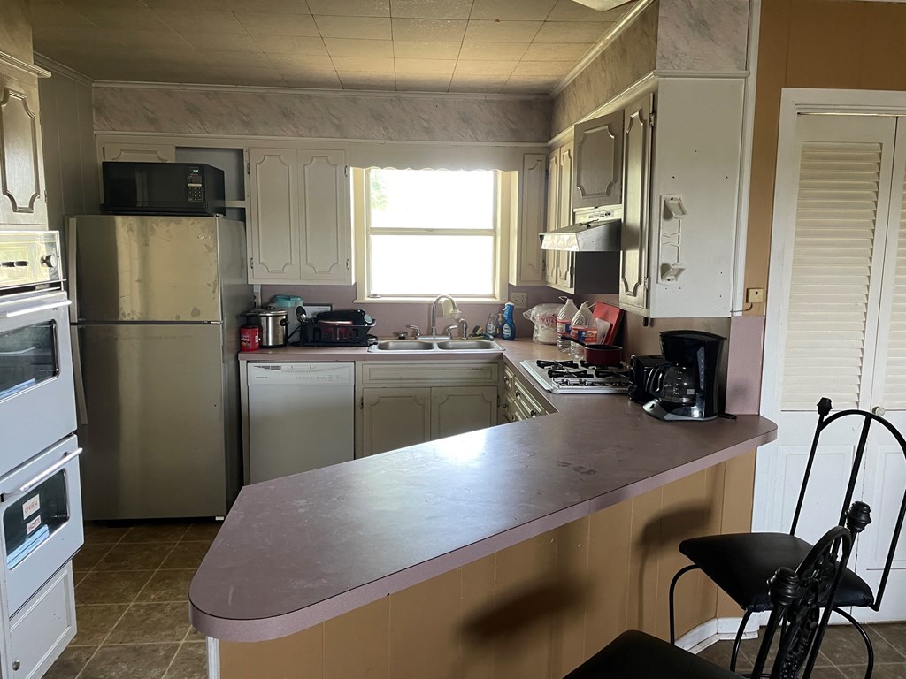 2204 Lange Polk Road Brady, TX 76825 - Photo 25 of 30 a kitchen with a table chairs refrigerator and cabinets