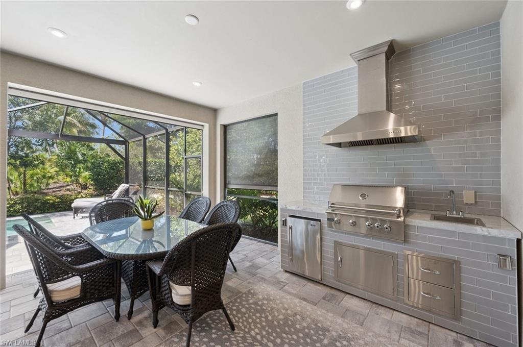 3171 Quilcene Lane Naples, FL 34114 - Photo 13 of 37 a kitchen with stainless steel appliances granite countertop a stove a sink a dining table and chairs