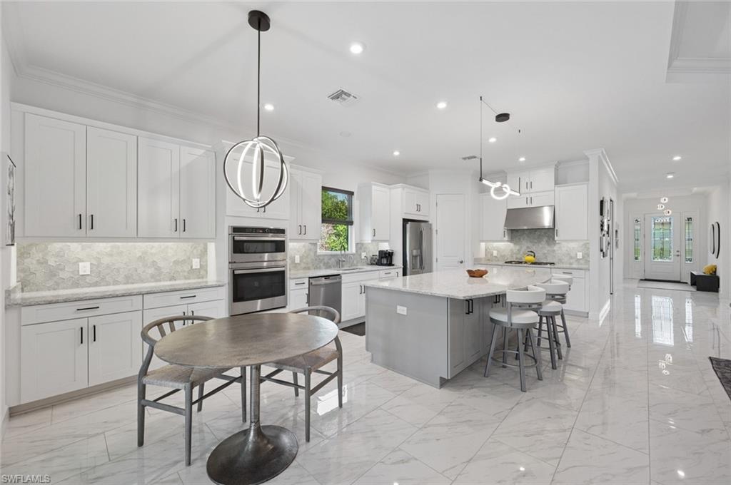 3171 Quilcene Lane Naples, FL 34114 - Photo 6 of 37 a large kitchen with a table and chairs in it