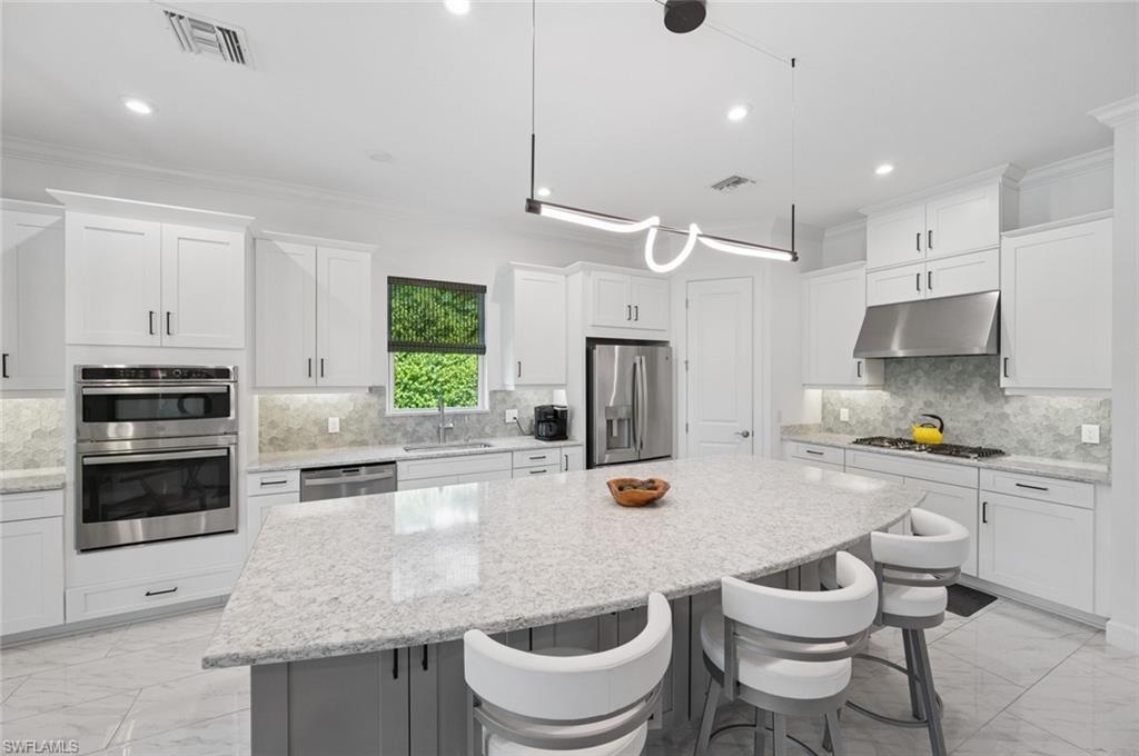 3171 Quilcene Lane Naples, FL 34114 - Photo 7 of 37 a kitchen with a stove a sink and a refrigerator