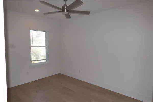 an empty room with a window and a fan
