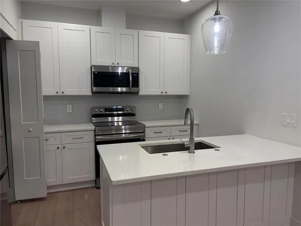 a kitchen with a sink and white cabinets