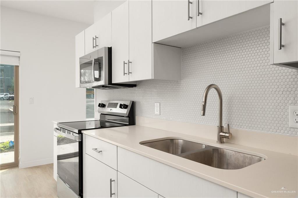 500 South Ware Road McAllen, TX 78501 - Photo 9 of 10 a kitchen with stainless steel appliances granite countertop a sink and white cabinets