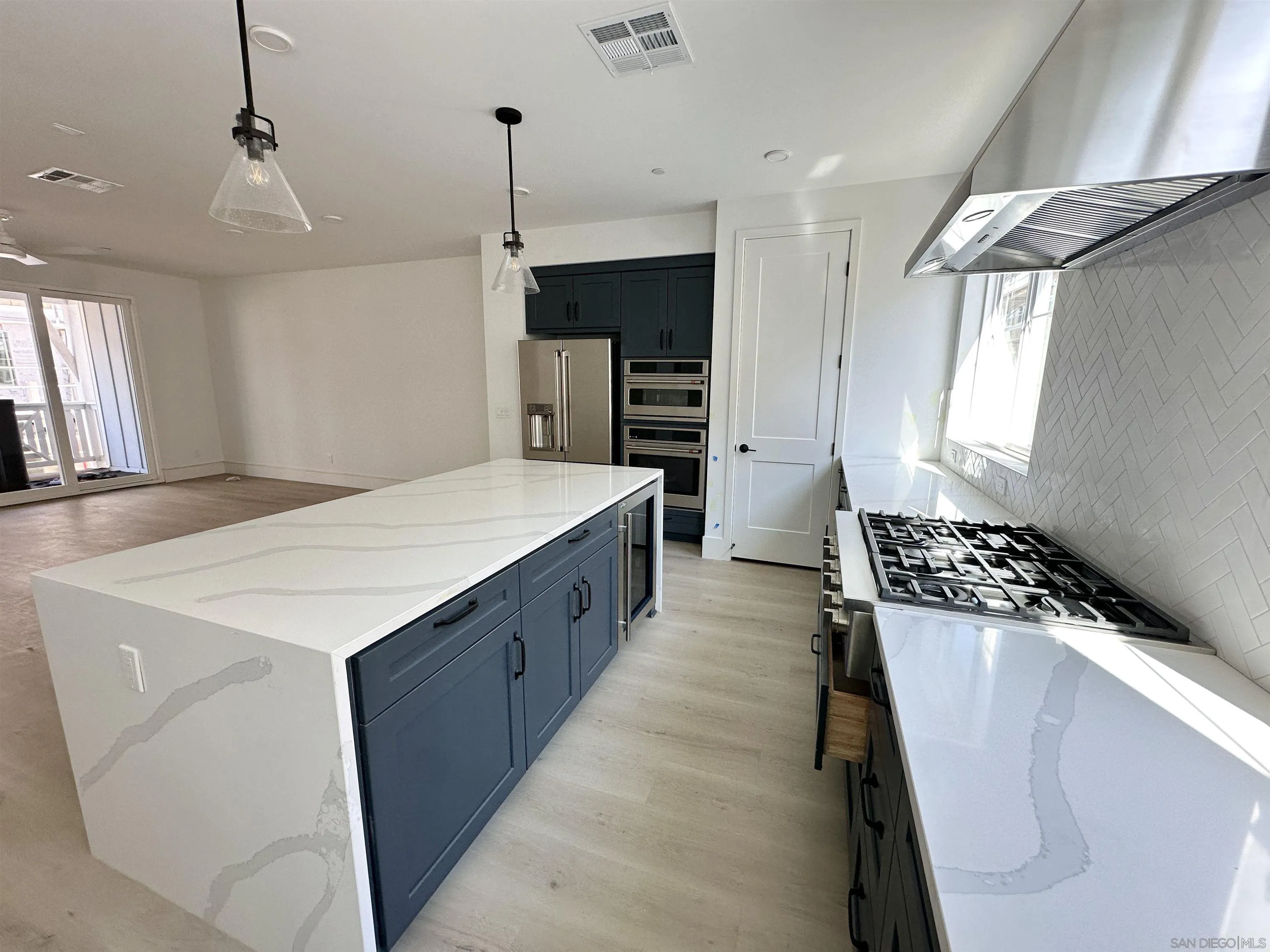 7290 Ponto Drive South, Unit 207 Carlsbad, CA 92011 - Photo 17 of 32 a large kitchen with stainless steel appliances granite countertop a sink a stove and a refrigerator
