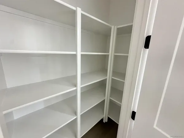 a view of walk in closet with empty racks