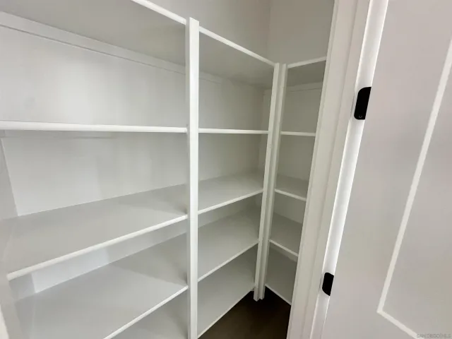 a view of walk in closet with empty racks
