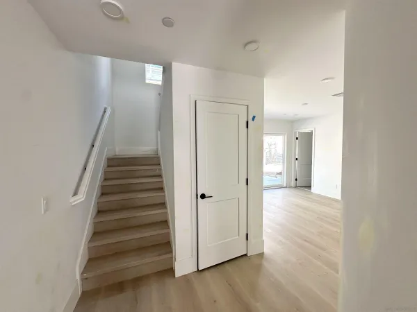 a view of a hallway with wooden floor and staircase