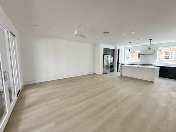wooden floor in an empty room with a kitchen