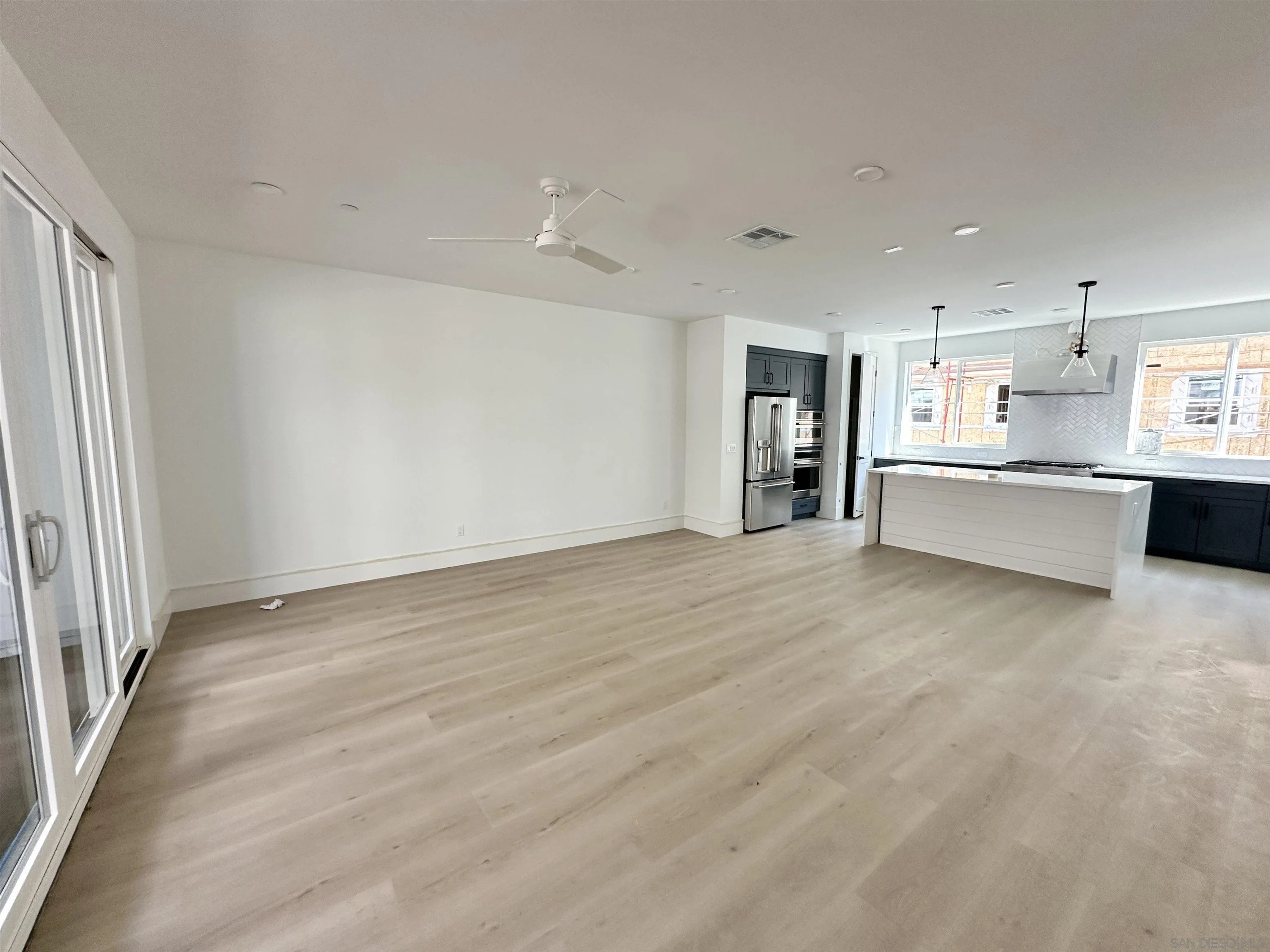 7290 Ponto Drive South, Unit 207 Carlsbad, CA 92011 - Photo 6 of 32 wooden floor in an empty room with a kitchen