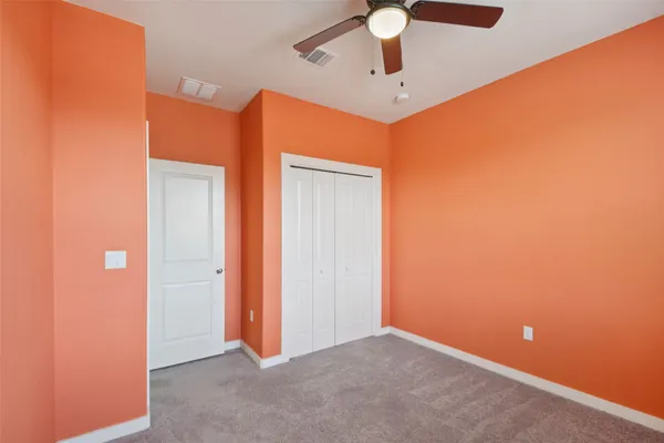 an empty room with a chandelier fan