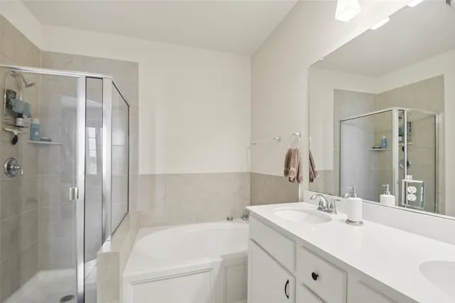 a bathroom with a tub sink and mirror