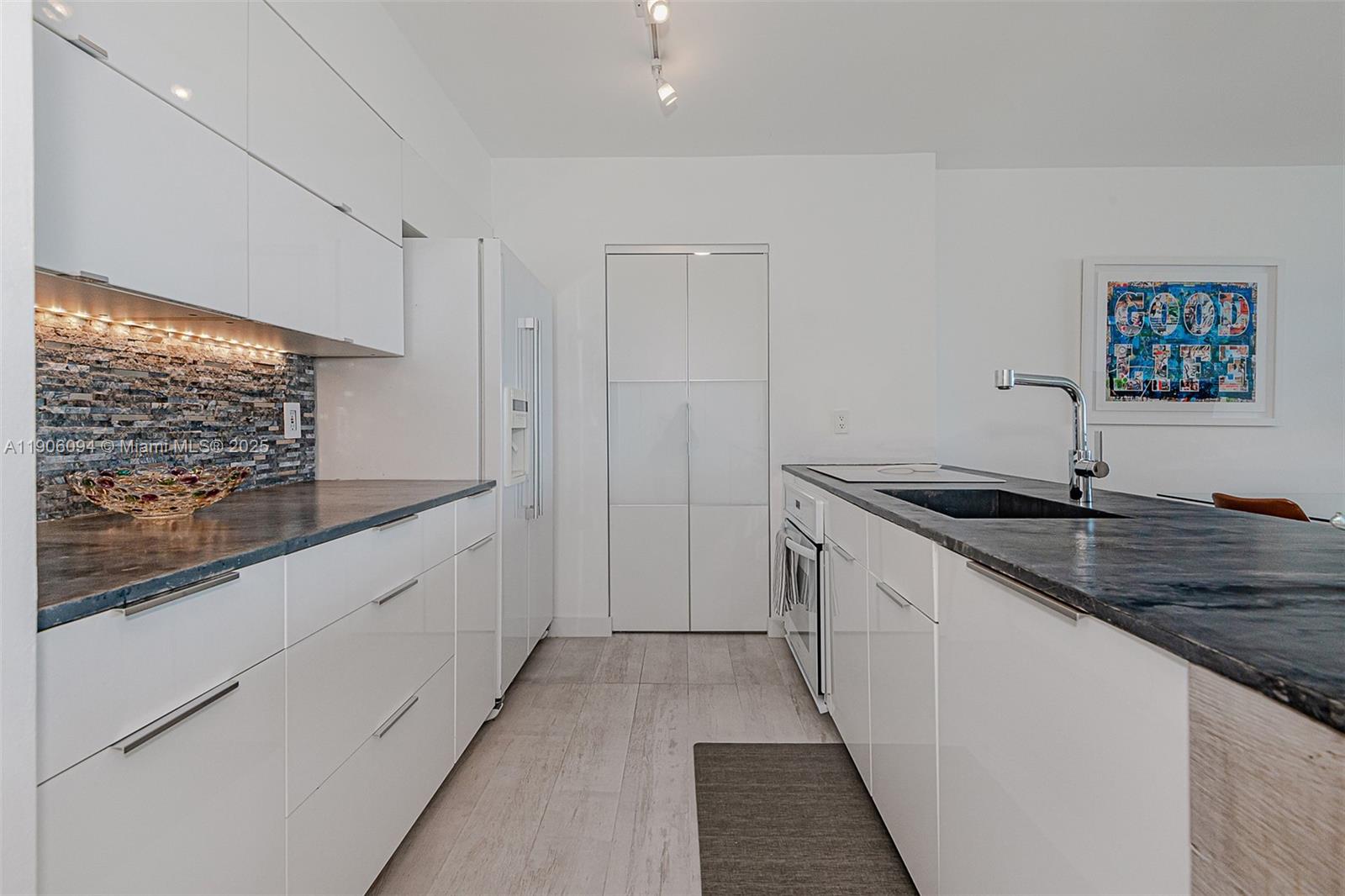 90 Alton Road, Unit 2506 Miami Beach, FL 33139 - Photo 13 of 22 a large white kitchen with a sink and dishwasher