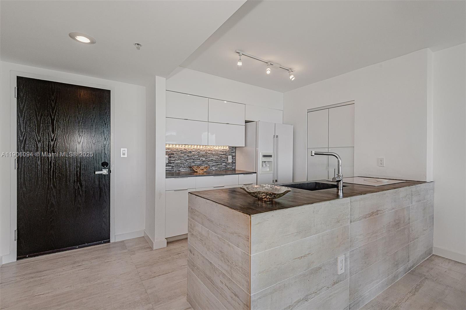 90 Alton Road, Unit 2506 Miami Beach, FL 33139 - Photo 10 of 22 a kitchen that has a stove and a refrigerator