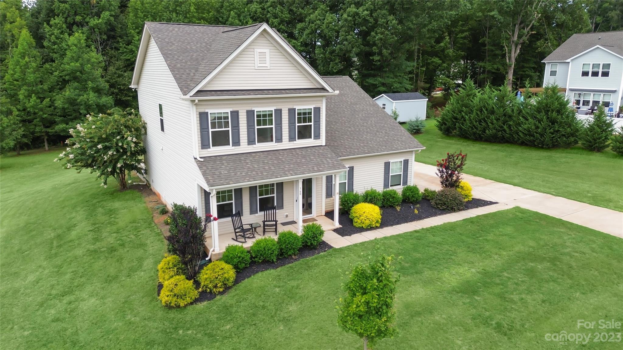 a view of a house with a yard and potted plants