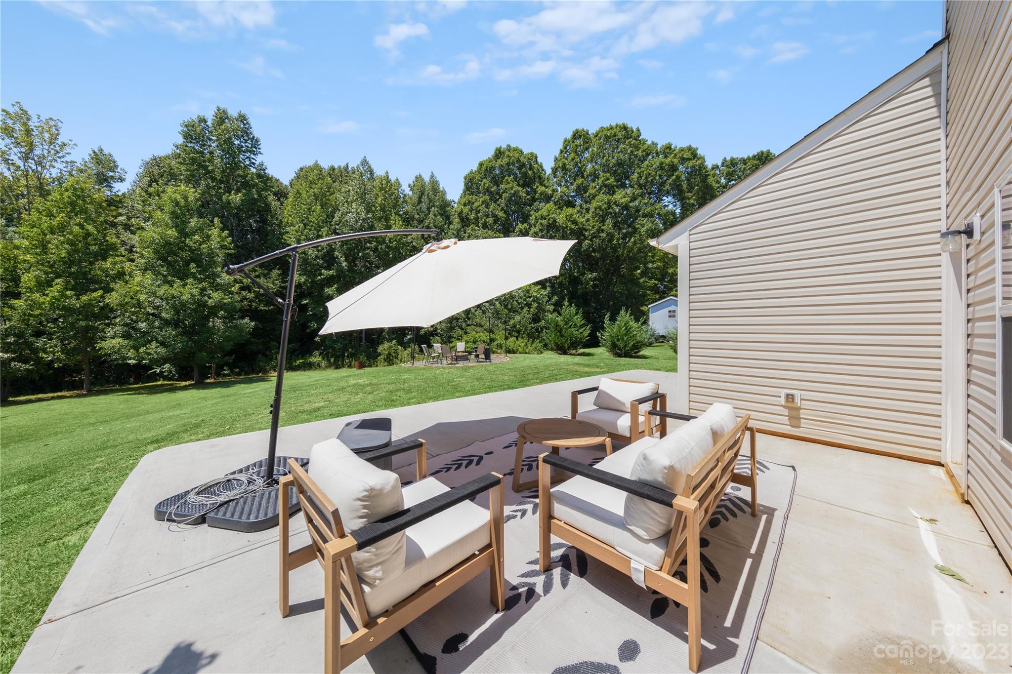 360 Wyndham Forest Circle Midland, NC 28107 - Photo 32 of 40 a view of a patio with a table chairs and a backyard