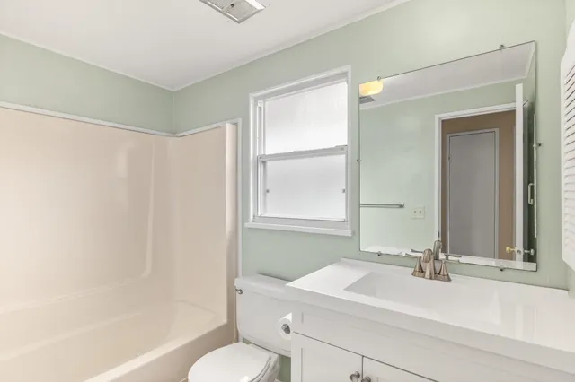 a bathroom with a sink mirror toilet and bathtub