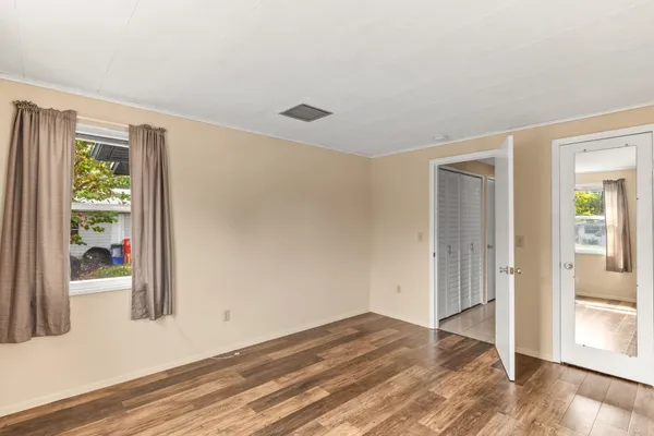 a view of a room with wooden floor and windows