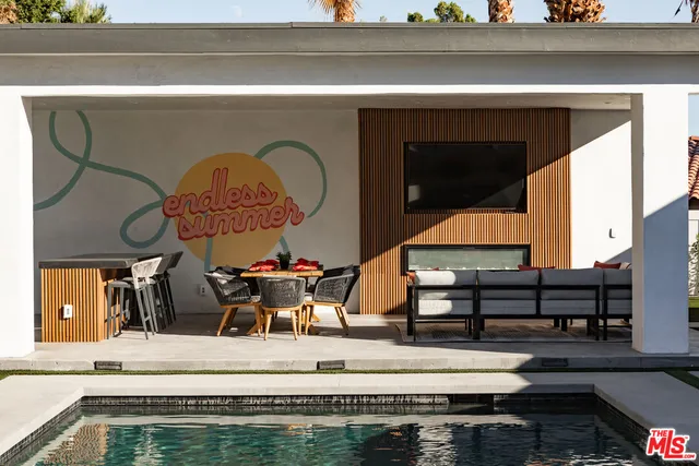 a living room with furniture a flat screen tv and a floor to ceiling window
