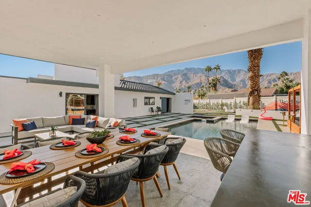 a dinning table and chairs in front of a house
