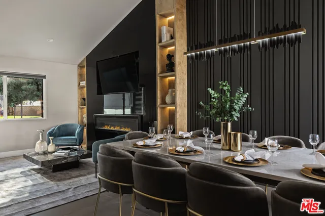 a kitchen with stainless steel appliances kitchen island granite countertop a refrigerator a stove a sink and a dining table with the kitchen view