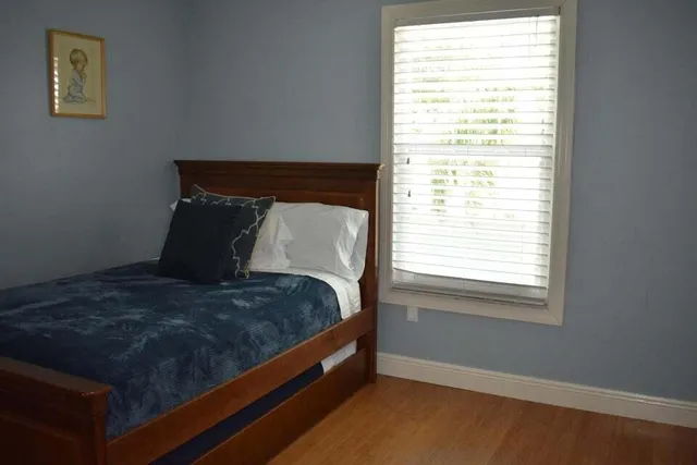 a bed sitting in a bedroom next to a window
