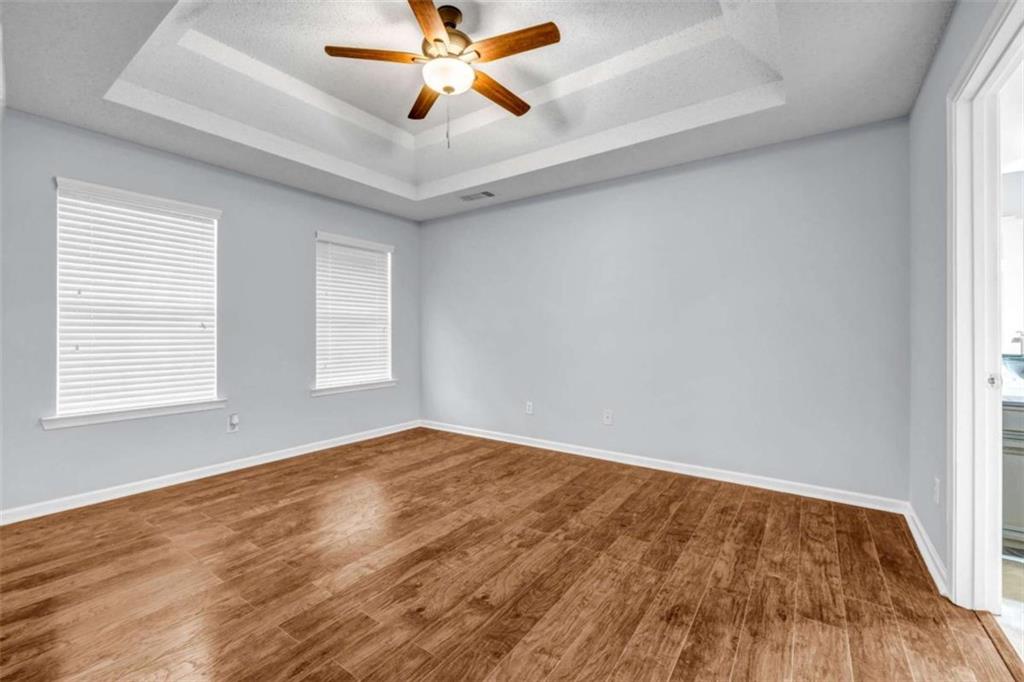 1903 Cobblestone Court Conyers, GA 30012 - Photo 14 of 30 an empty room with wooden floor fan and windows