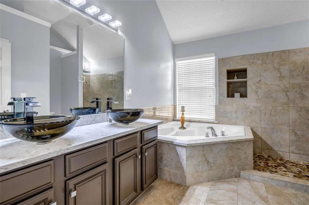 1903 Cobblestone Court Conyers, GA 30012 - Photo 16 of 30 a bathroom with a tub sink and mirror