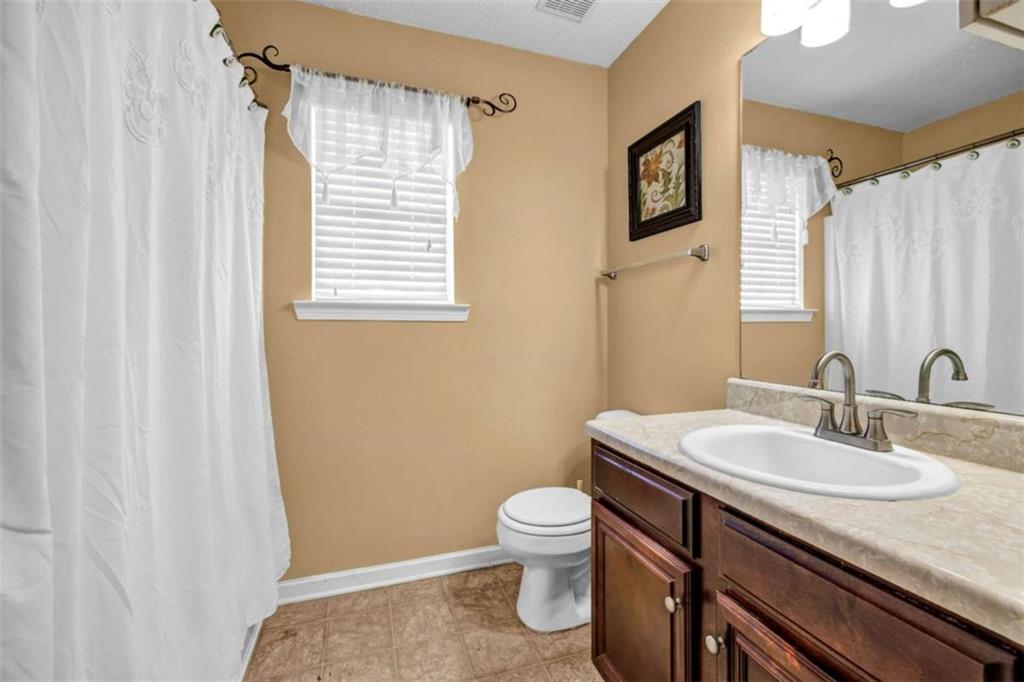 1903 Cobblestone Court Conyers, GA 30012 - Photo 26 of 30 a bathroom with a sink a toilet and a mirror