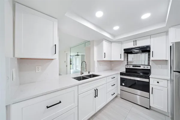 a kitchen with white cabinets and stainless steel appliances