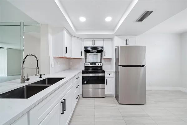 a kitchen with a sink cabinets and stainless steel appliances