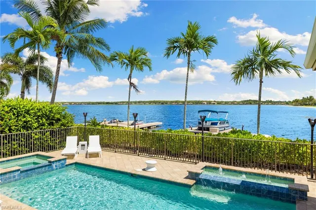 a view of a swimming pool with a garden and patio