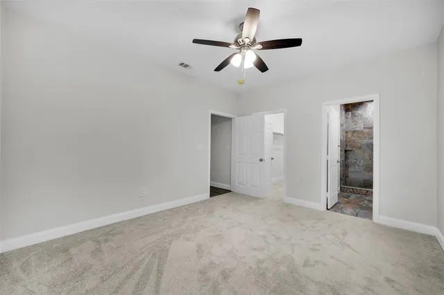 an empty room with ceiling fan and window