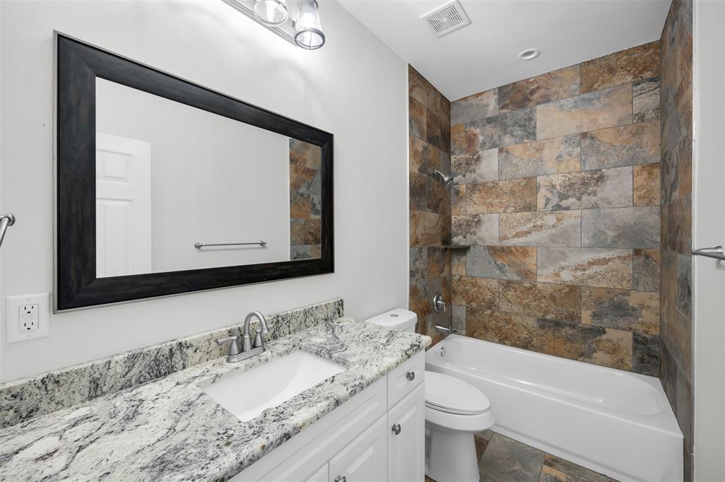 407 Dallas Street Rice, TX 75155 - Photo 19 of 25 a bathroom with a granite countertop sink a toilet and a mirror