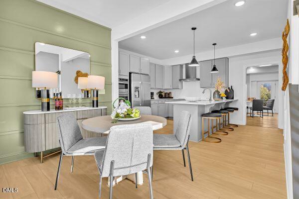605 Hedrick Ridge Road, Unit 105 Cary, NC 27519 - Photo 2 of 34 a kitchen with stainless steel appliances kitchen island granite countertop a dining table chairs and a refrigerator
