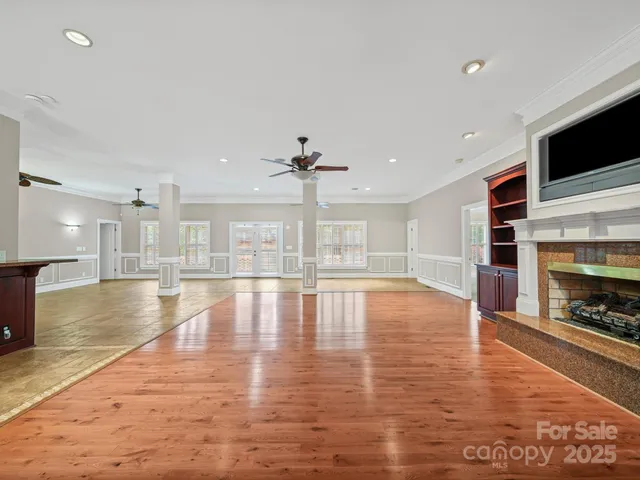 a view of empty room with wooden floor and fireplace