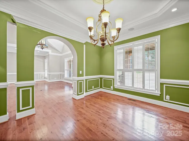 a view of a room with wooden floor fan and windows