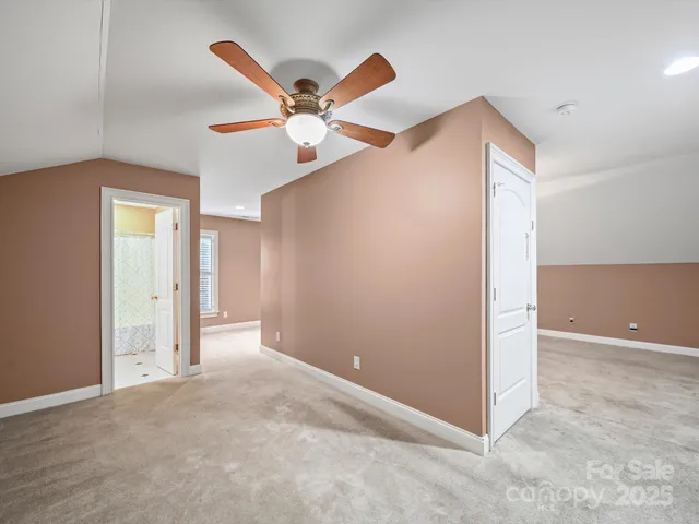 an empty room with closet and a chandelier fan