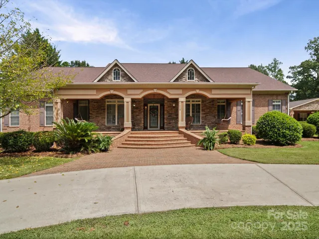 a front view of a house with a yard and potted plants