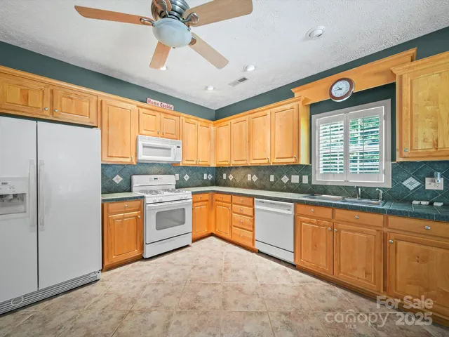 a large kitchen with stainless steel appliances granite countertop a stove cabinets and a refrigerator