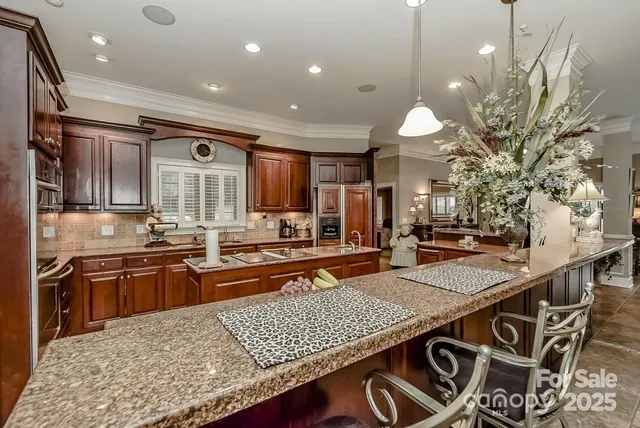 a kitchen with stainless steel appliances granite countertop a stove a sink and a refrigerator