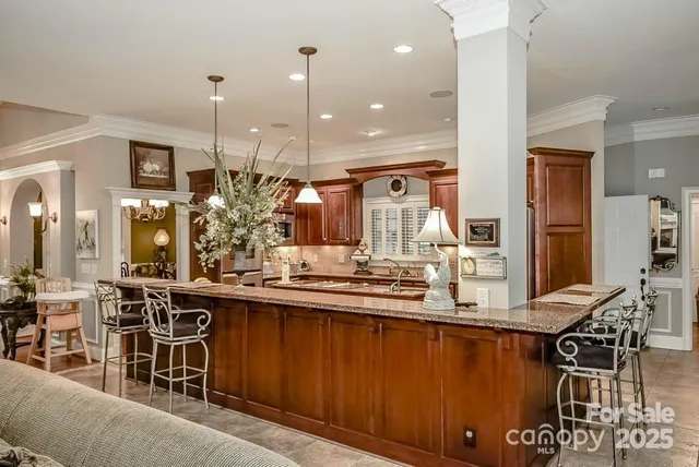 a kitchen with stainless steel appliances kitchen island granite countertop a stove and a sink