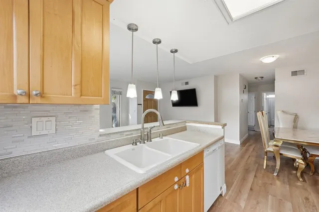 a kitchen with a sink and a wooden floor