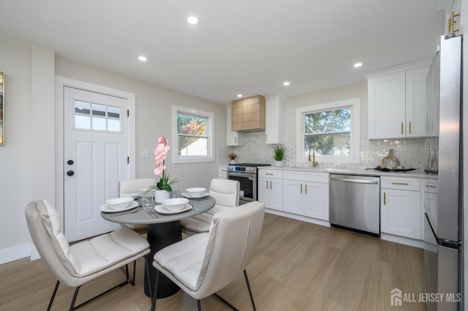333 1st Street Middlesex, NJ 08846 - Photo 7 of 24 a kitchen with a dining table chairs and white appliances