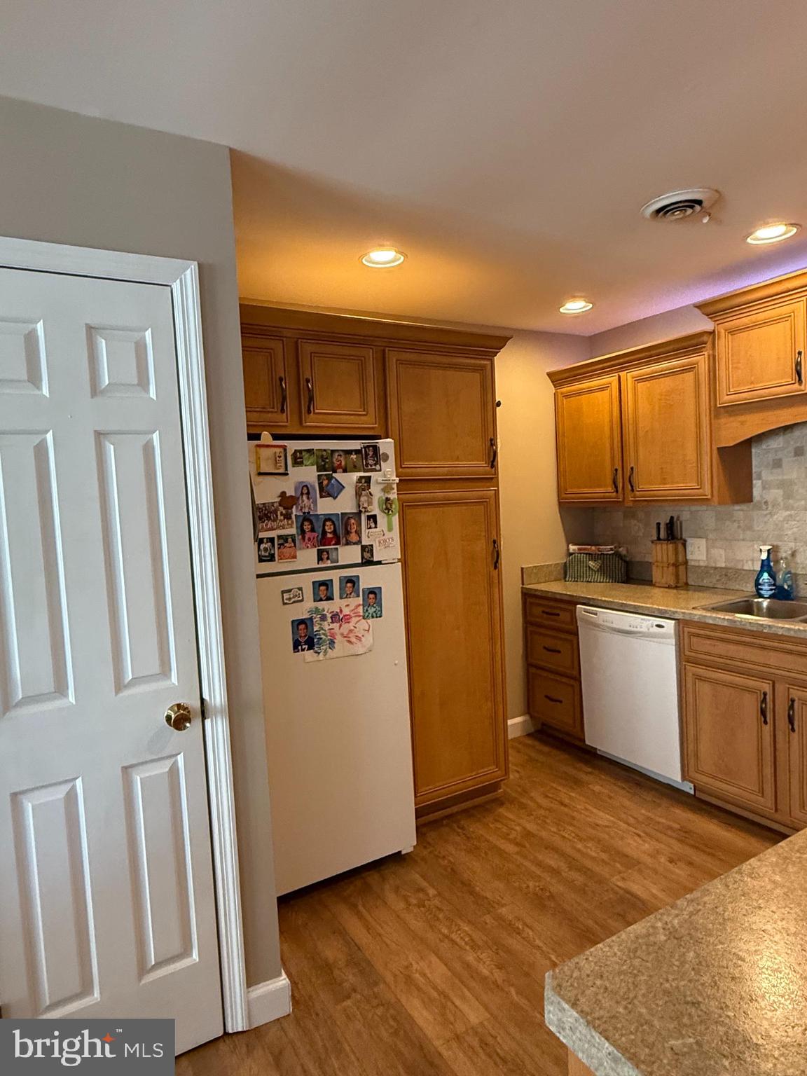 4713 Charles Road Mechanicsburg, PA 17050 - Photo 6 of 19 a kitchen with granite countertop a refrigerator and wooden floor