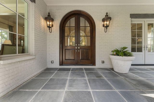 a living room with furniture large window and wooden floor