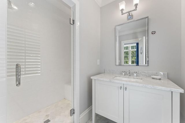 a view of a white house with large windows and a small yard