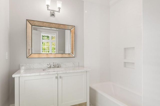 a view of a backyard with table and chairs potted plants and large tree