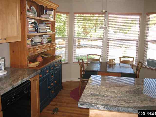 10415 Nighthawk Circle Reno, NV 89523 - Photo 7 of 13 a living room with kitchen island granite countertop wooden floor and large windows