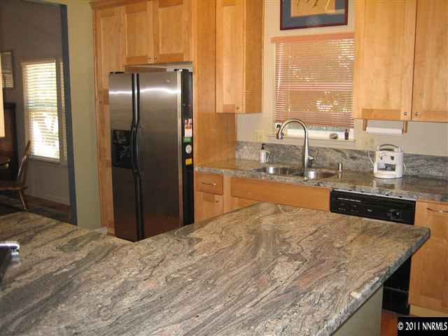 10415 Nighthawk Circle Reno, NV 89523 - Photo 10 of 13 a kitchen with stainless steel appliances granite countertop a refrigerator and a sink